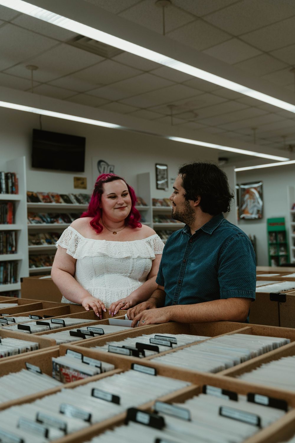 Couple smiles at each other while browsing record bins in a vintage music store.