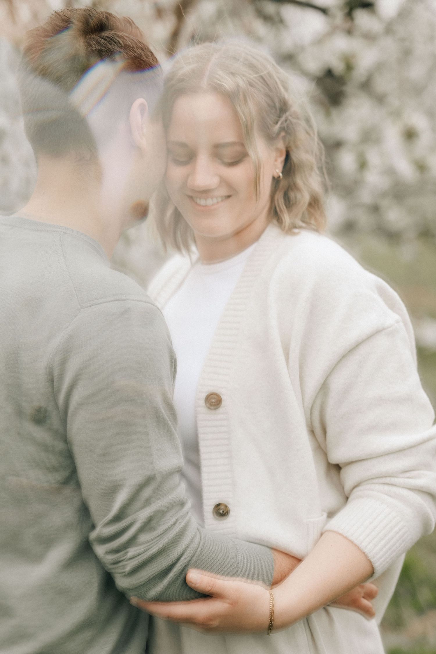 lächelnde Frau schmiegt sich bei ihrem Partner an beim Hochzeitskennenlernshooting in Jork