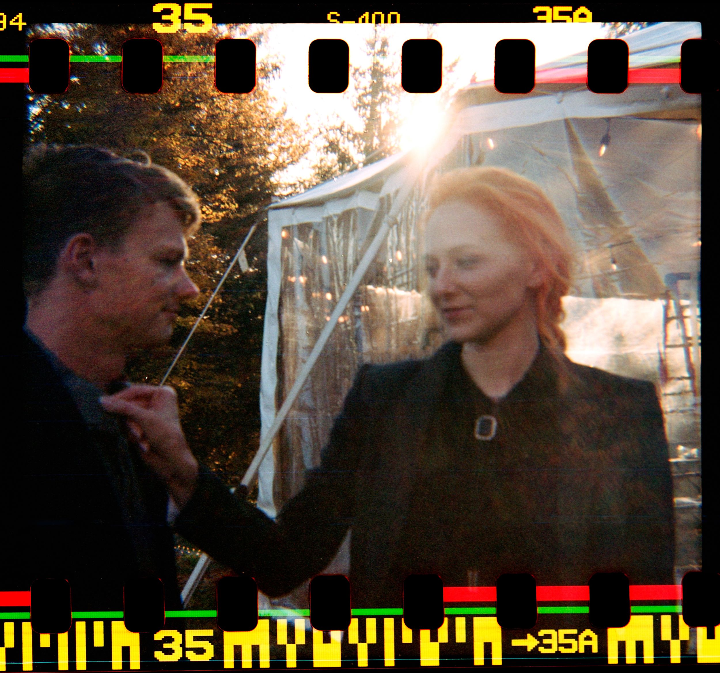 Double exposure film photo of two people outdoors in golden sunlight.
