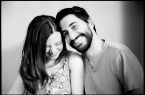 Black and white portrait of a smiling couple leaning close together affectionately.