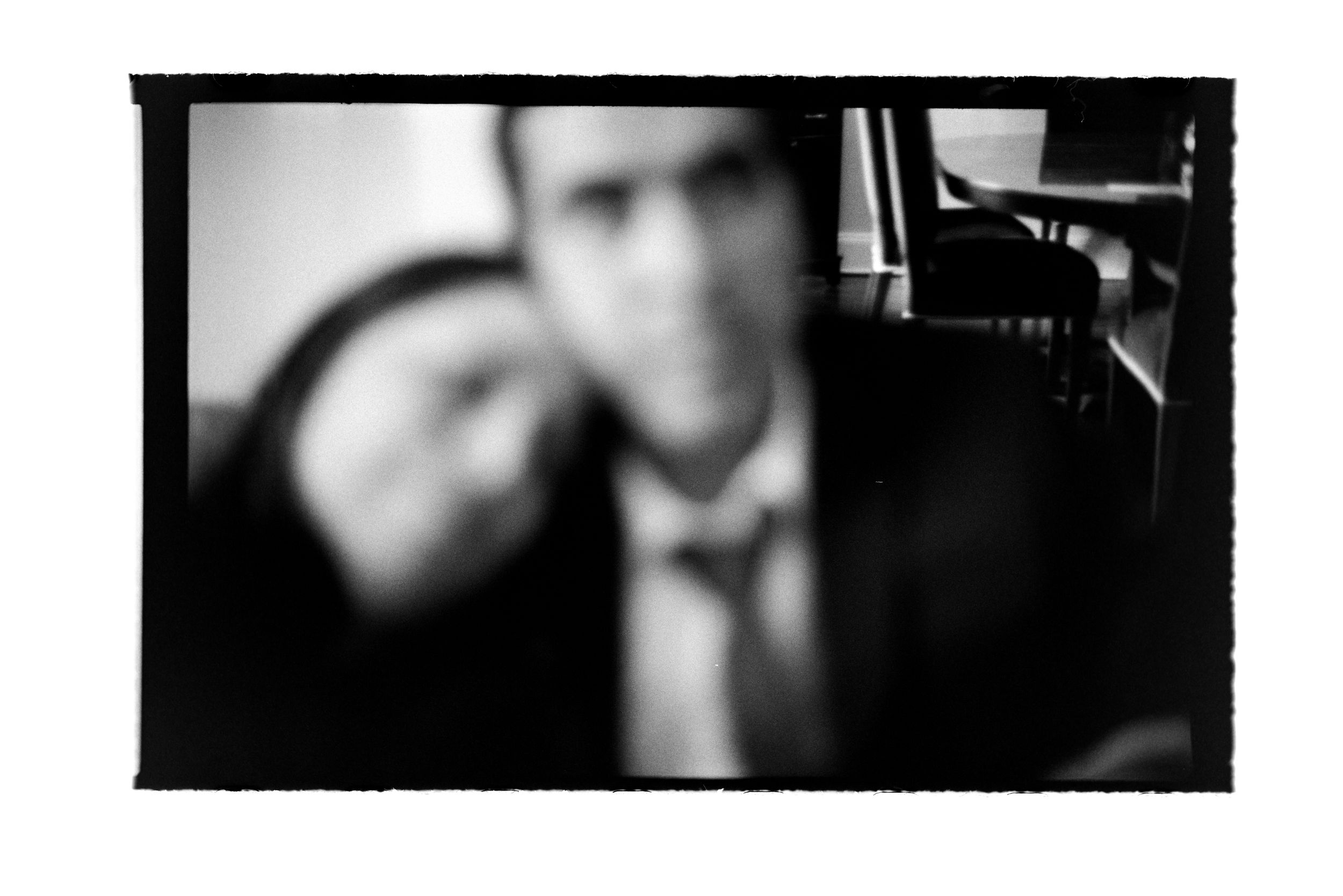 Blurry black and white portrait of a man in a suit and tie with a soft-focus vintage aesthetic.