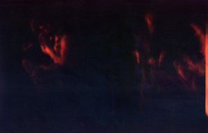 Abstract dark red and black artistic photo with shadowy figures and dramatic lighting effects.