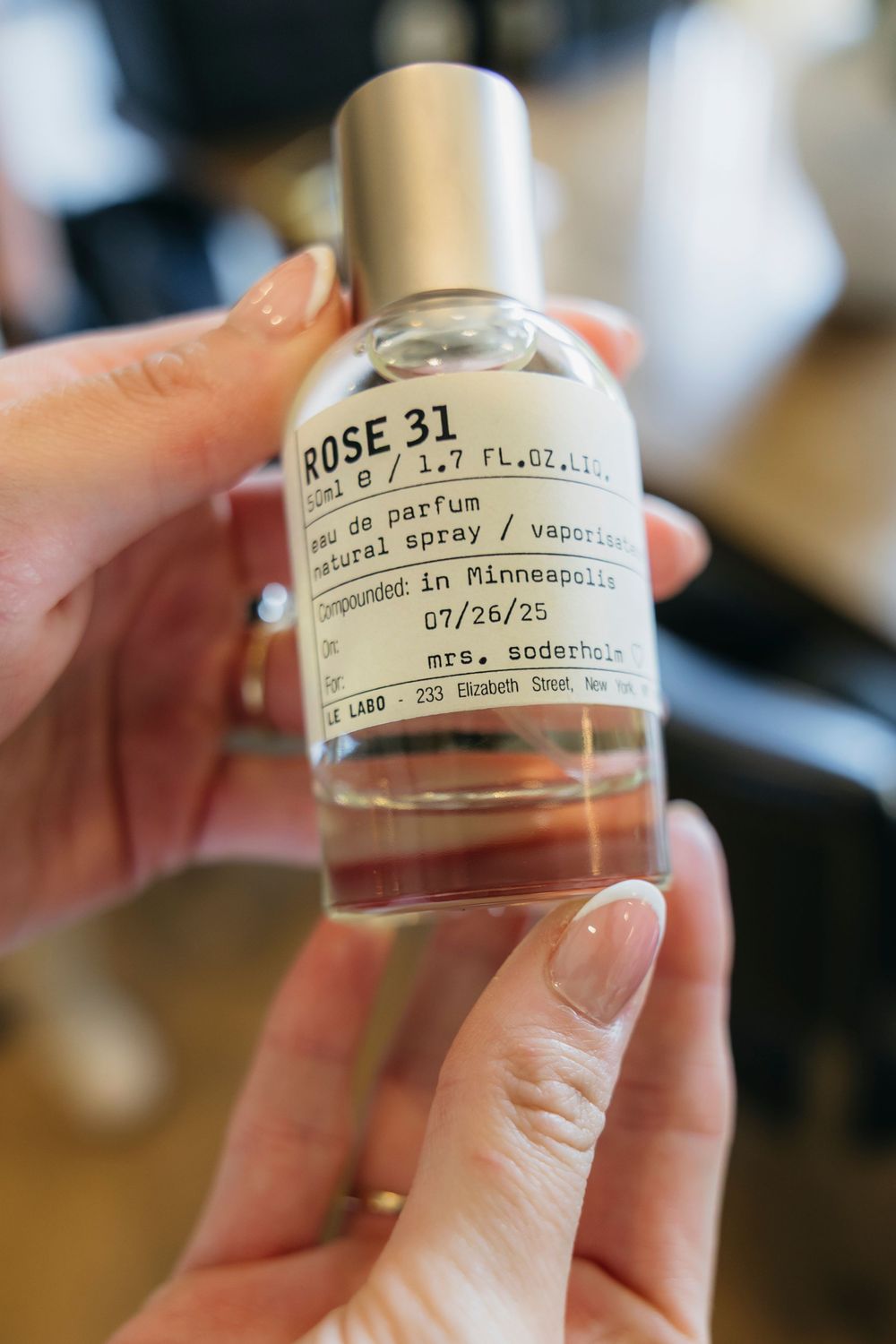 Hands holding a Le Labo Rose 31 eau de perfume bottle, 1.7 oz natural spray, compounded in Minneapolis as wedding getting ready details