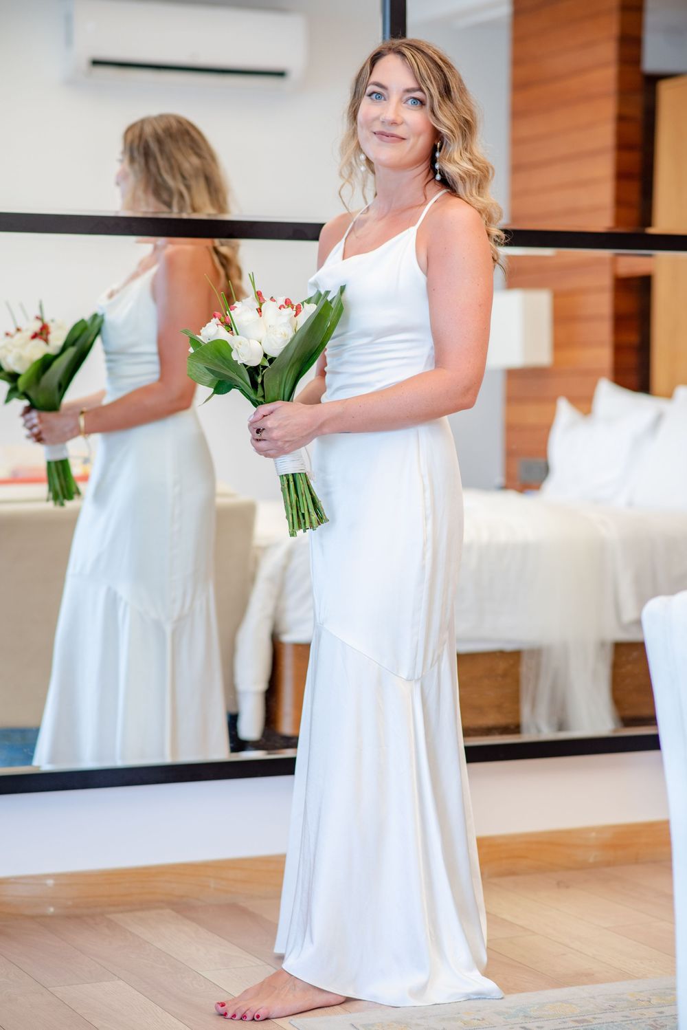 A series of photos showing someone in a flowing white wedding dress holding a green and white bouquet in an indoor setting.