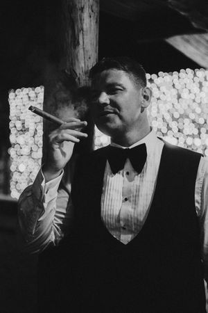 A black and white sequence of four vintage photographs showing a person in a vest and dress shirt smoking.