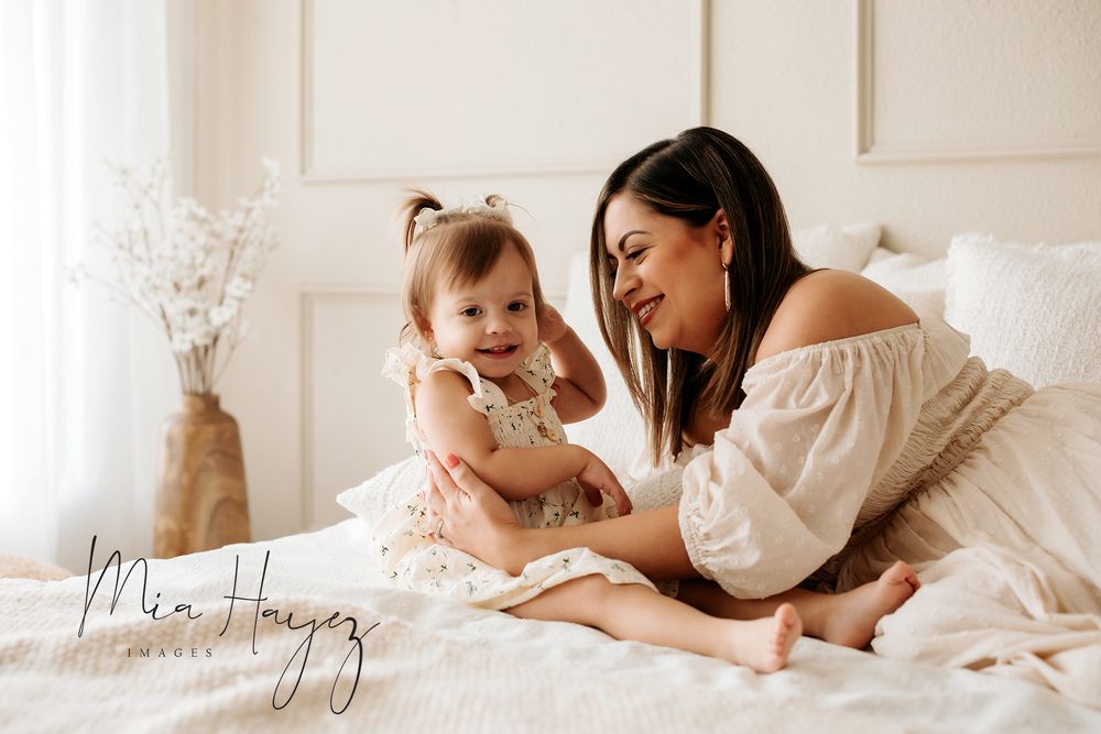 Tender family moments captured in soft white tones during an intimate lifestyle photoshoot.