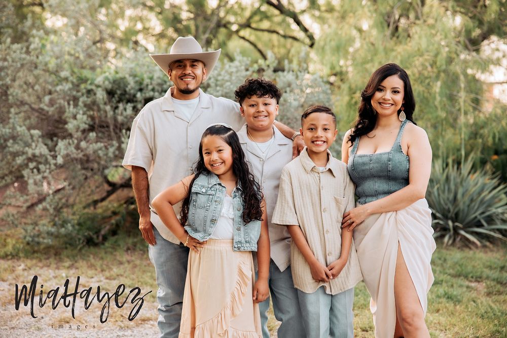 Outdoor family photography session in neutral tones against a desert landscape.