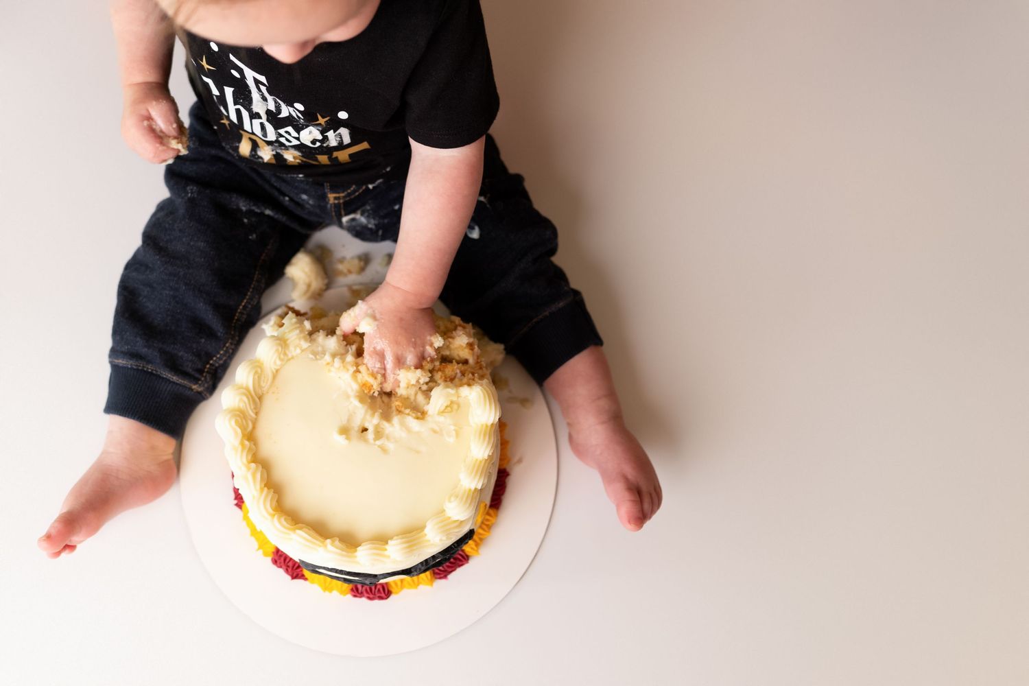Close-up shots of hands reaching for a birthday cake on white surface.