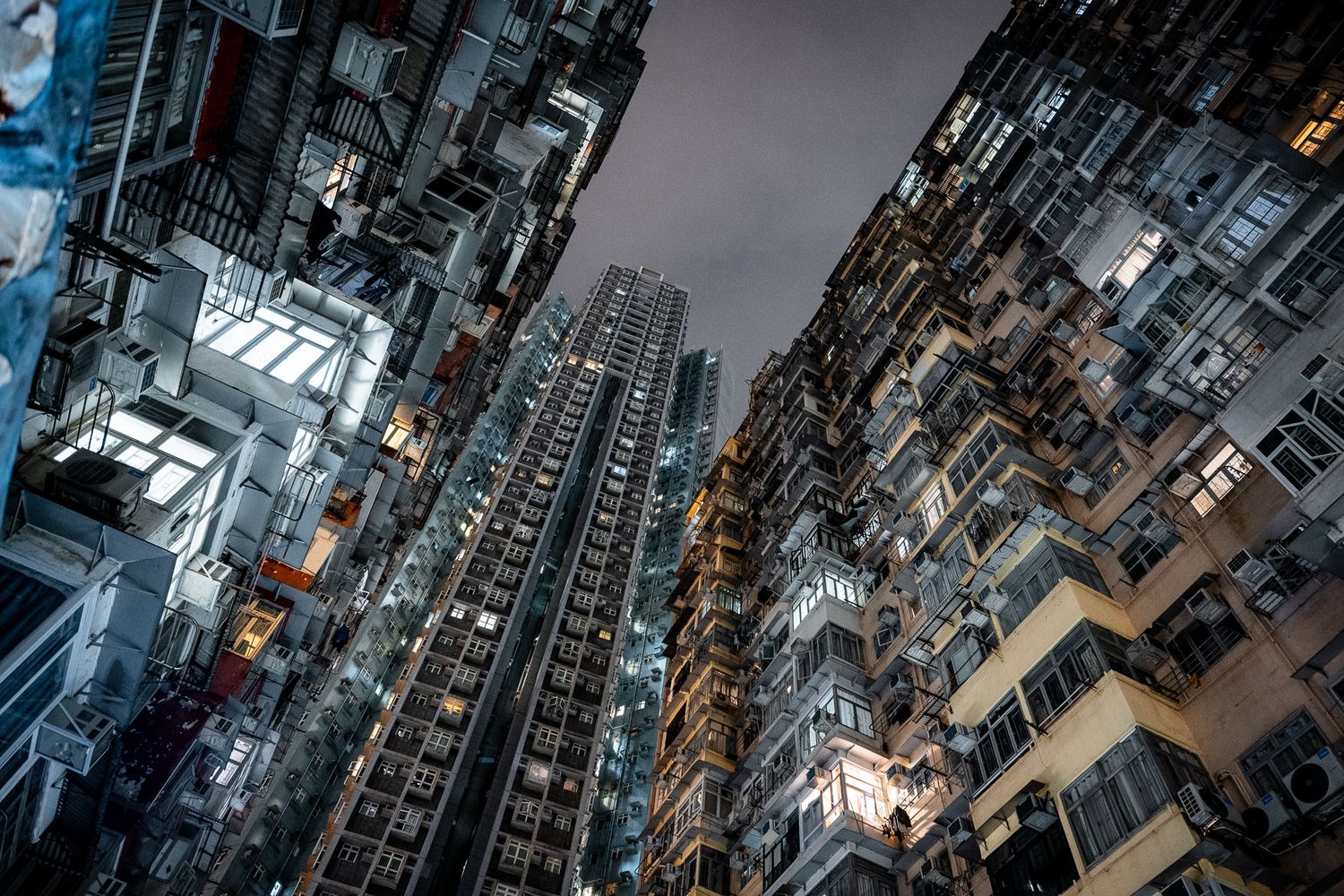 Dense urban residential towers shot from below creating dramatic vertical perspective.