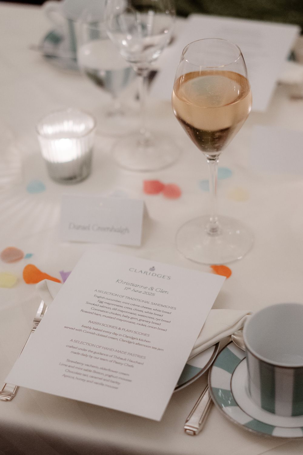 Elegant table setting at a formal event with white menu cards and wine glasses arranged in a row.