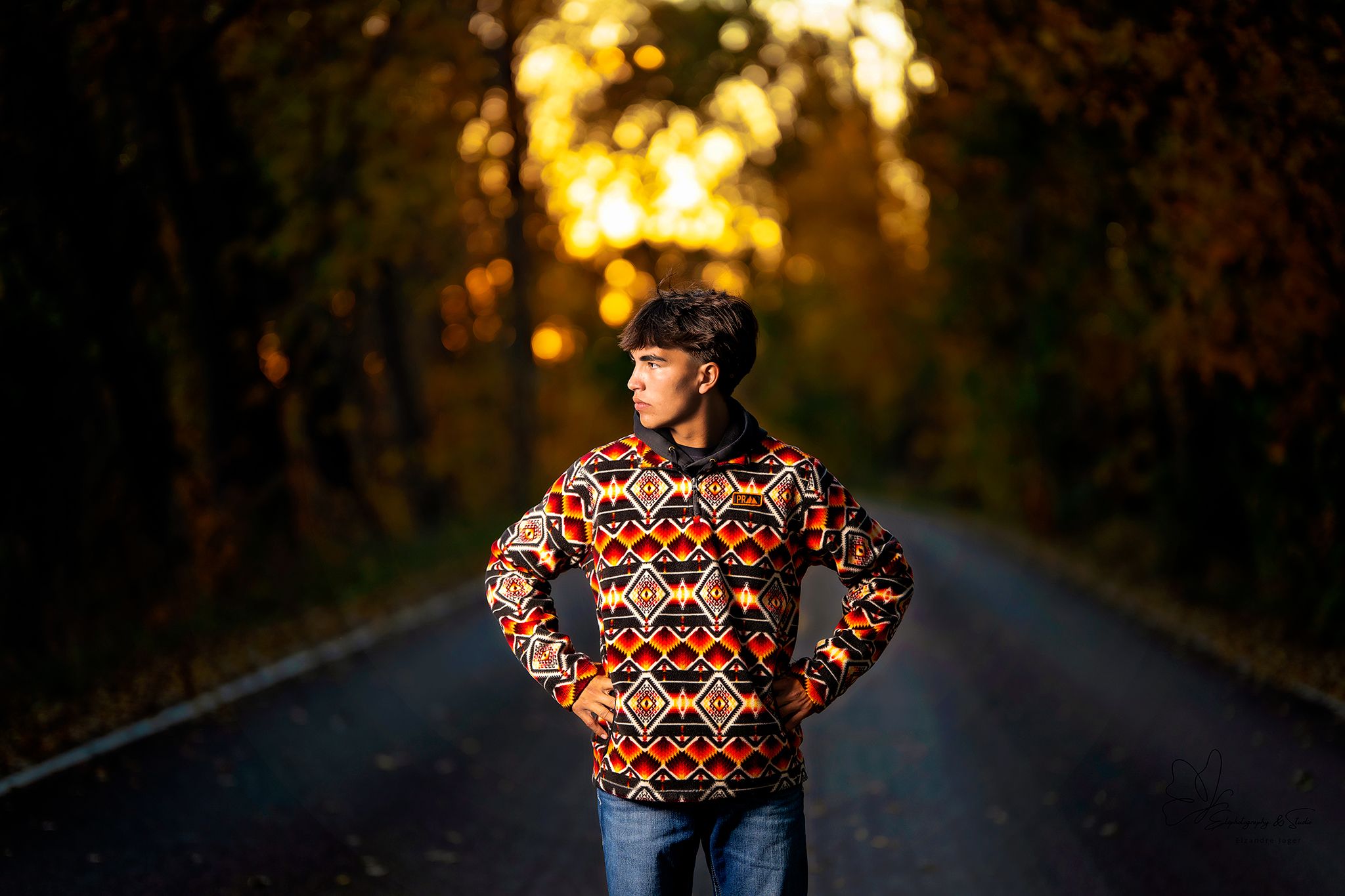 Moody autumn portrait on dark road with orange sunset lighting in Williston, North Dakota.