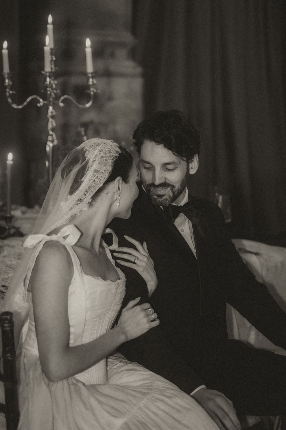 Romantic black and white wedding photo series showing intimate moments between newlyweds with candlelit ambiance.