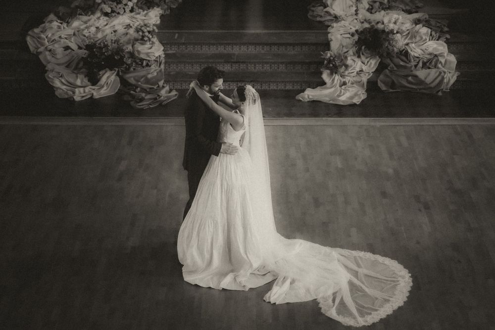 A series of black and white wedding photos showing a bride in a flowing white dress and veil against a dark background.