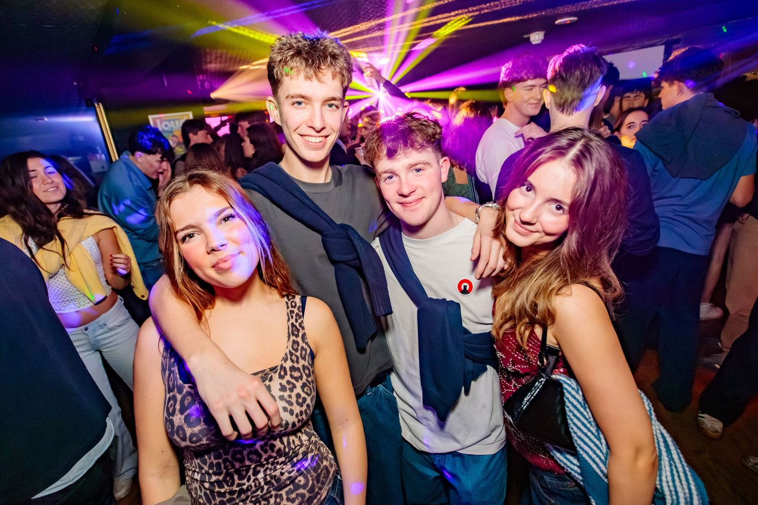 Dance club with dramatic blue lighting and people enjoying the party atmosphere.