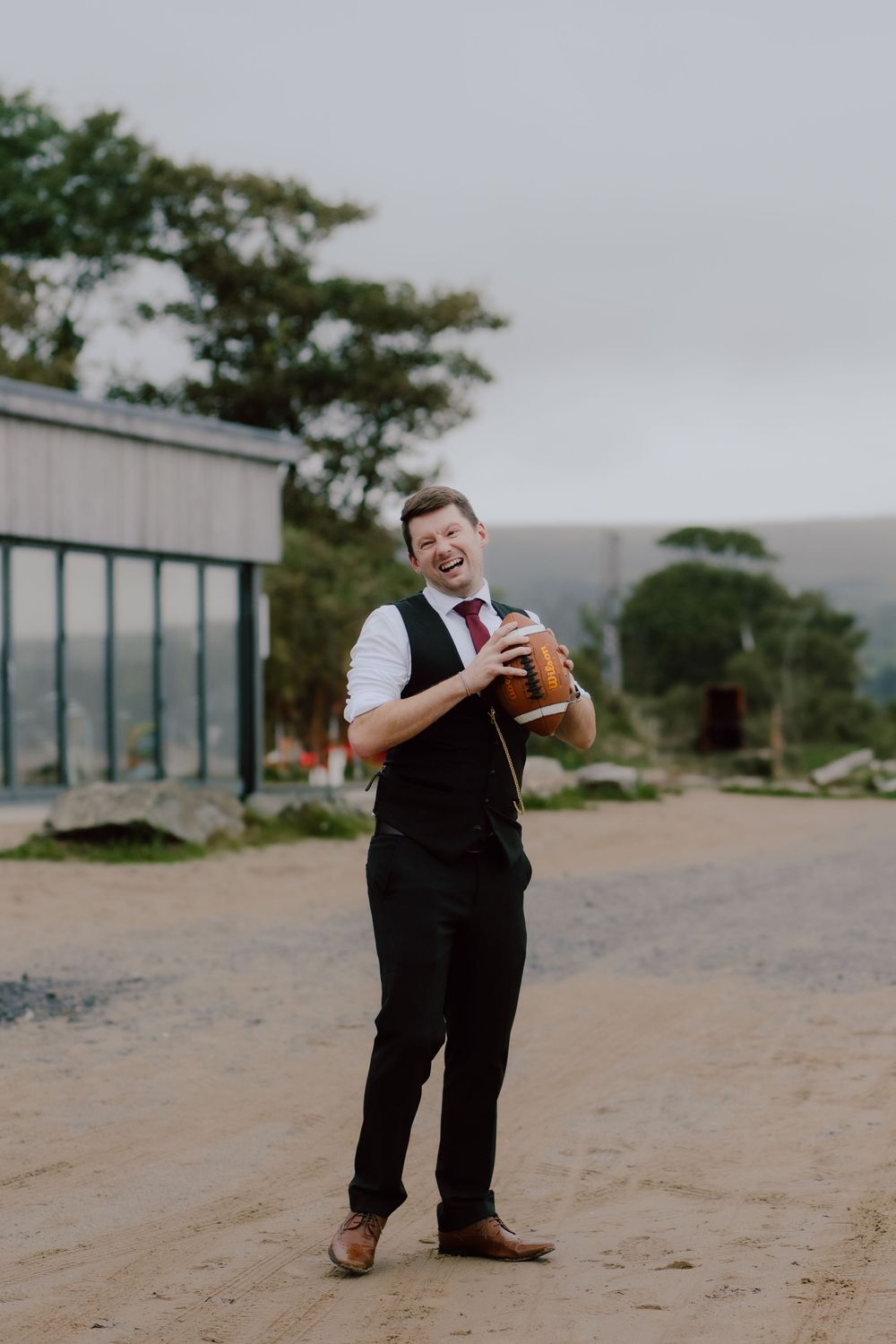 A series of four progressive photos showing someone in formal attire playfully dancing on a dirt road.