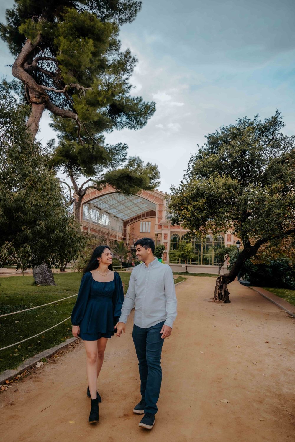 Joyful couple spinning around in the park path.