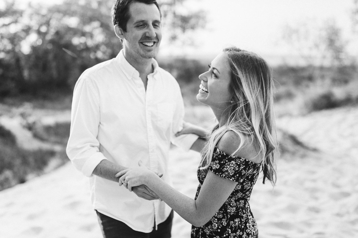 A couple shares a romantic moment together outdoors in black and white photography.