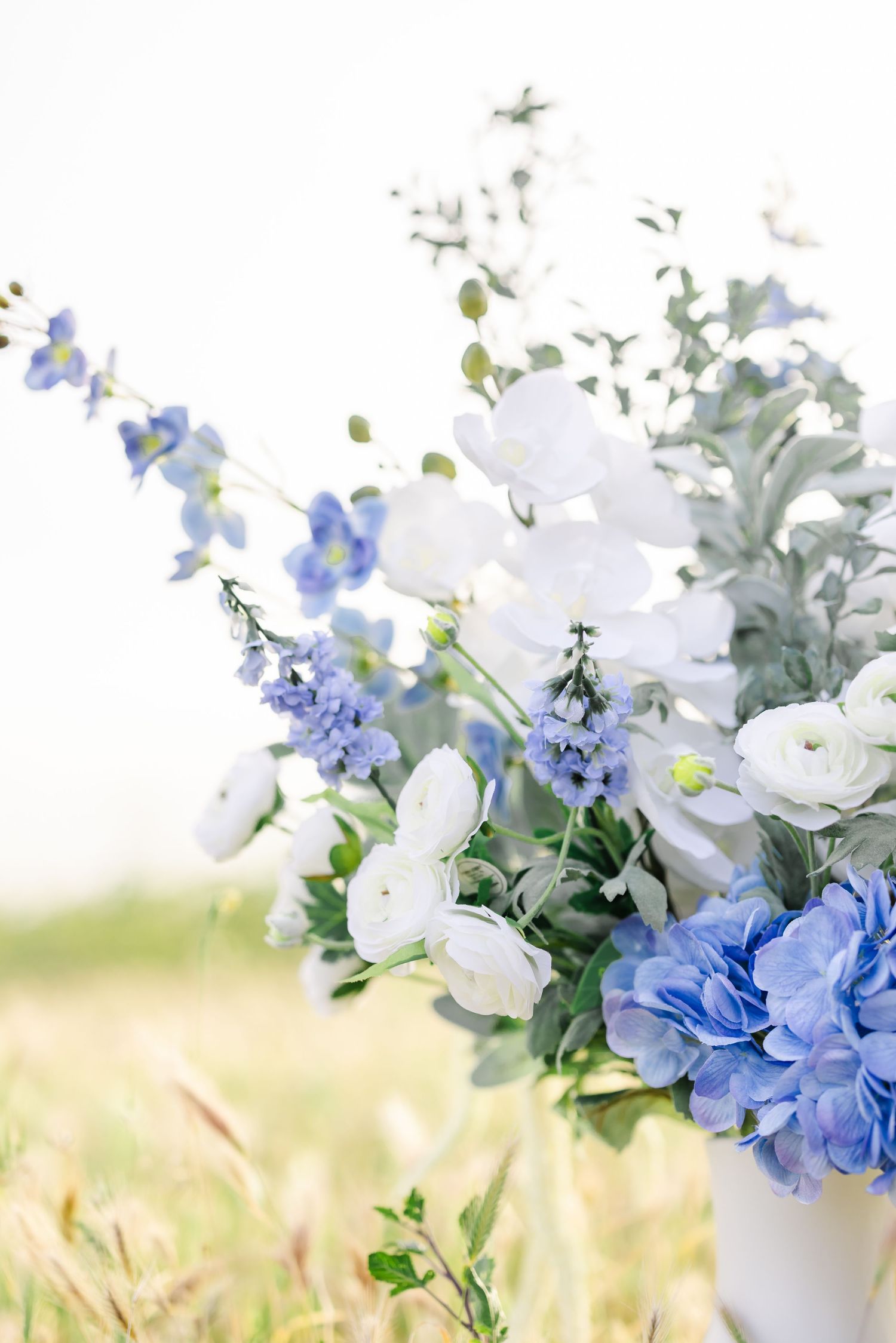 Delicate arrangement of white and blue flowers with soft focus creating a romantic atmosphere.