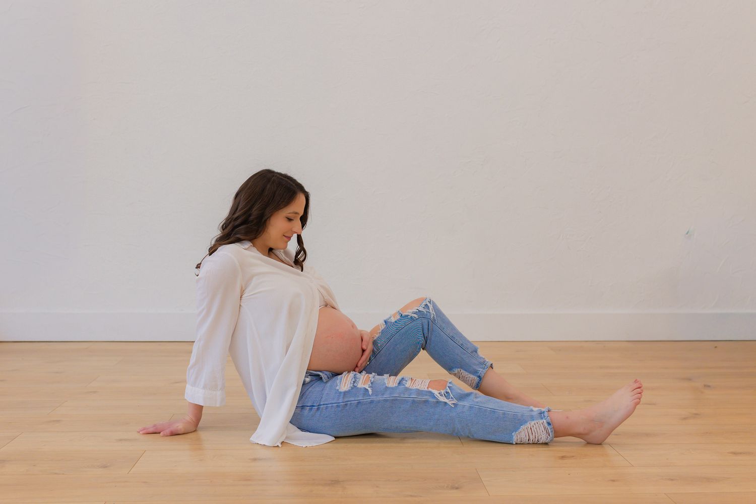 Expecting mother soaking in her pregnancy during her cozy maternity session