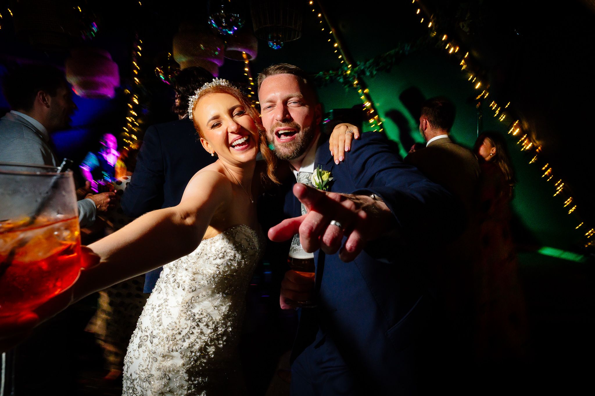 Wedding reception dance party with colorful lighting and energetic celebrations. Woodhill Hall.