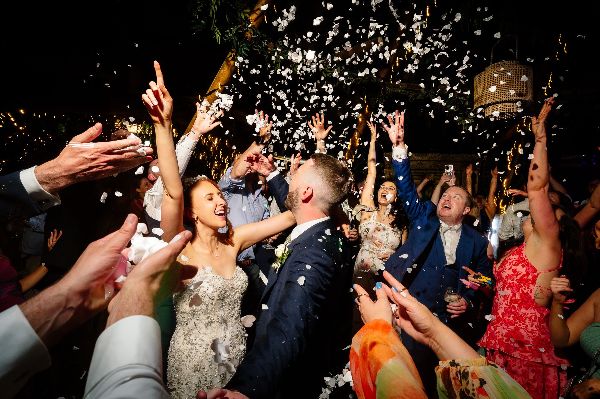 Wedding guests throw confetti during a lively reception celebration. Woodhill Hall.