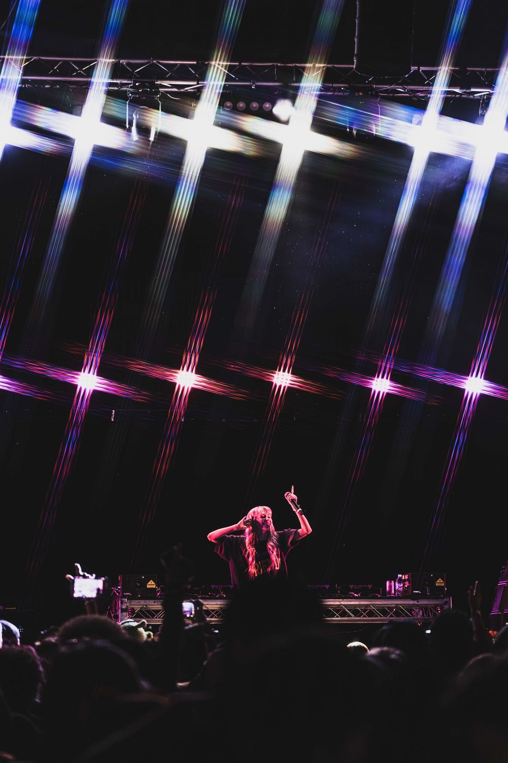 Concert stage with pink and blue lighting effects creating star-like patterns against a dark backdrop.
