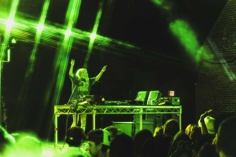 Concert stage illuminated with bright green lighting effects creating an atmospheric performance environment.