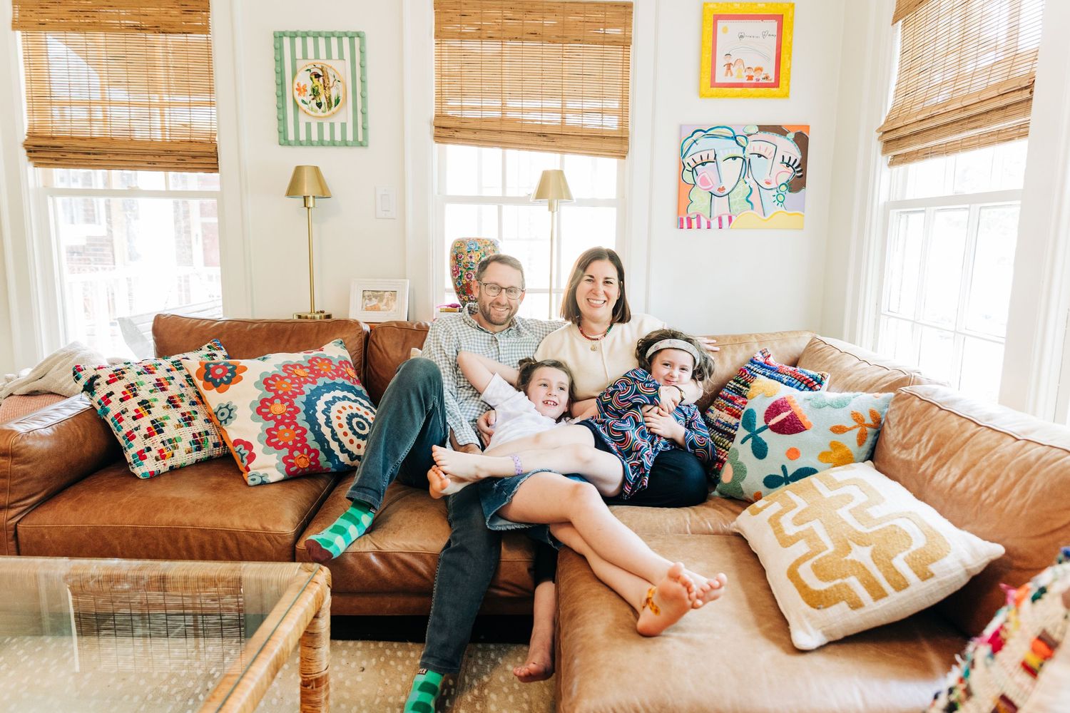 Cozy living room scene with bamboo window shades, decorative pillows, and natural light streaming through windows of Charlotte family.