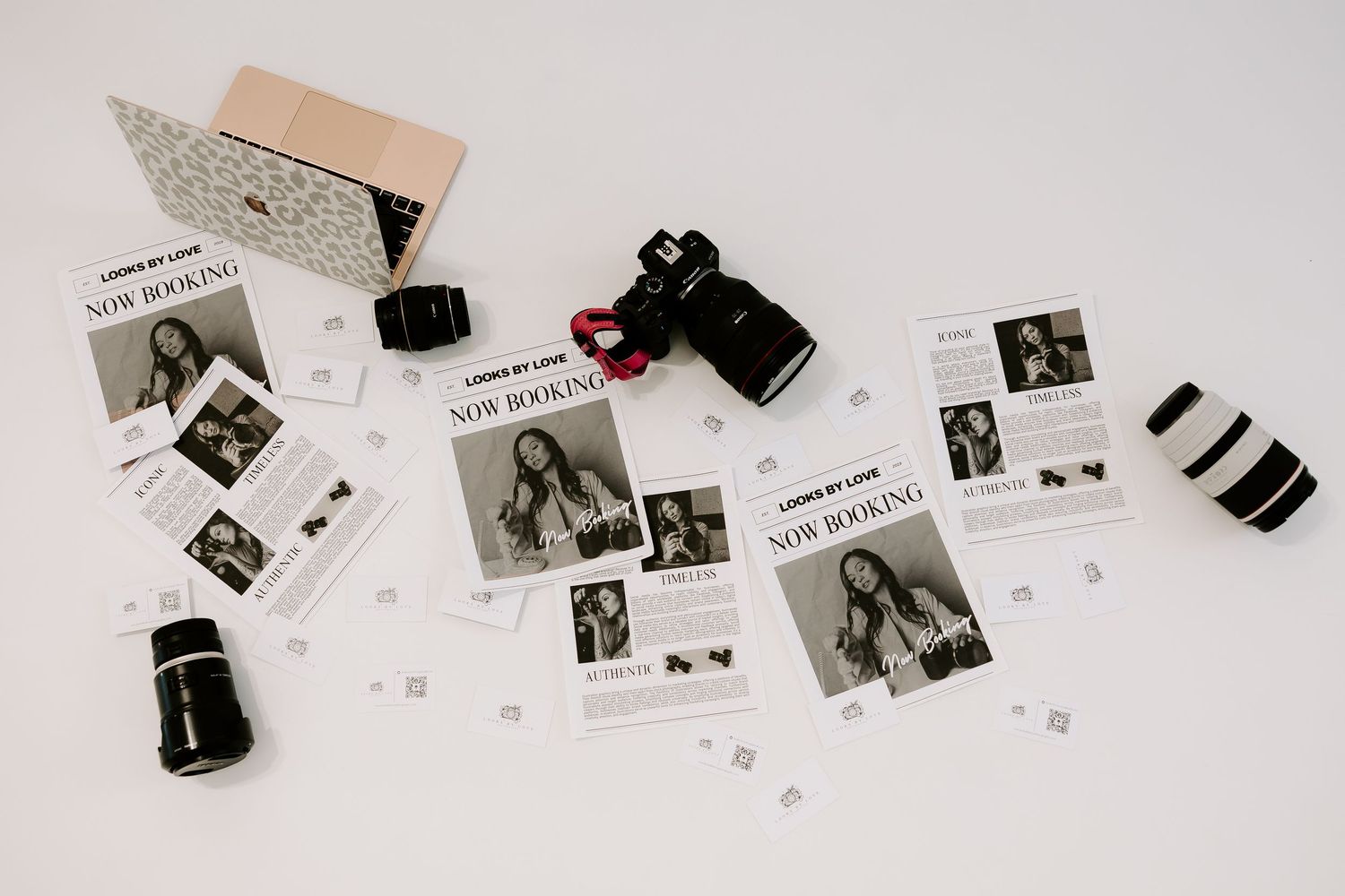 Black and white film negatives and prints scattered on a white surface in an artistic arrangement.
