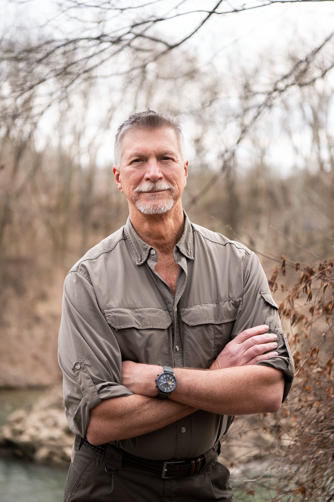 Outdoor portrait series showing a person in a gray button-down shirt against a natural wooded background.