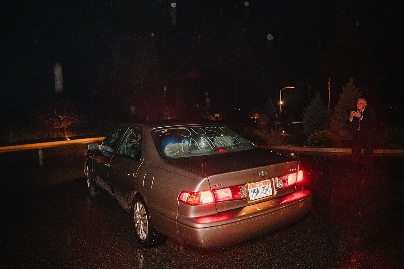 Dark nighttime scene showing parked cars with red taillights glowing on a residential street.
