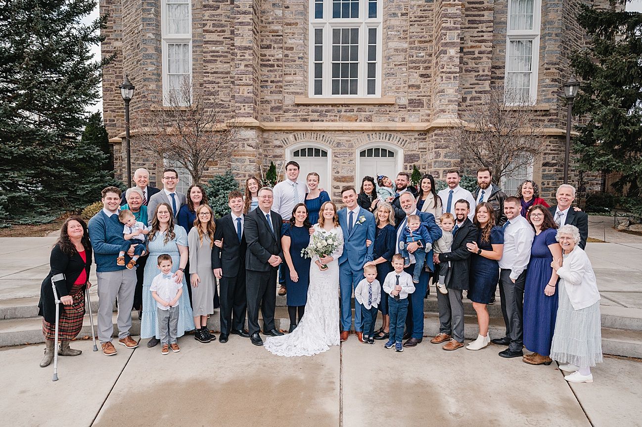 Wedding party group photos lined up outside a historic stone building with elegant architecture and landscaping.
