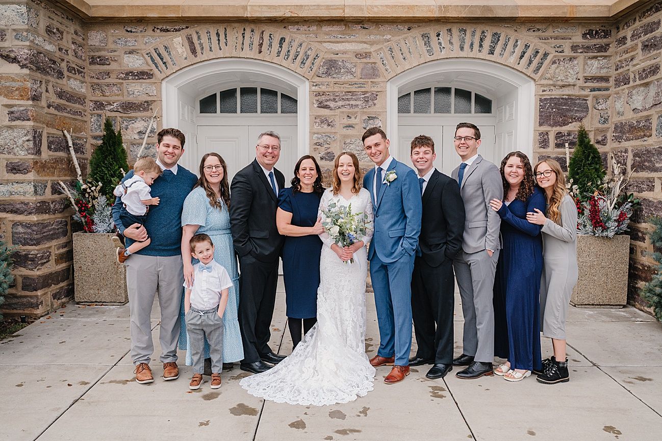 A series of family group photos taken outside a stone building in coordinated blue and neutral outfits.