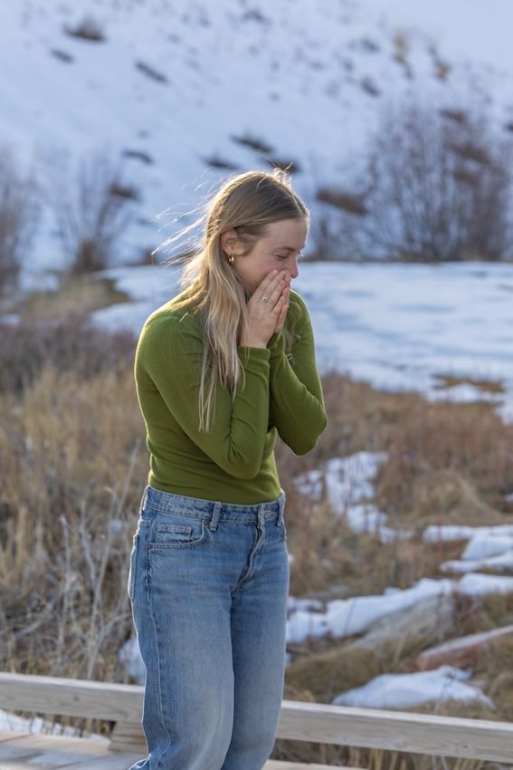 A series of emotional reaction shots in a snowy winter setting showing someone in a green sweater and jeans.