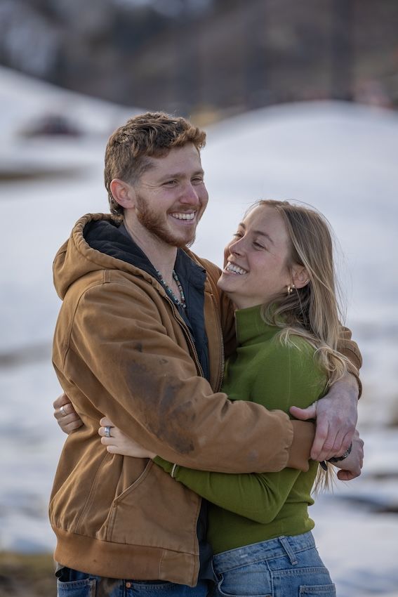 A sweet winter engagement moment captured in a series showing a couple embracing in the snow.