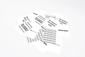 Scattered black text snippets on white paper creating a minimalist artistic arrangement.
