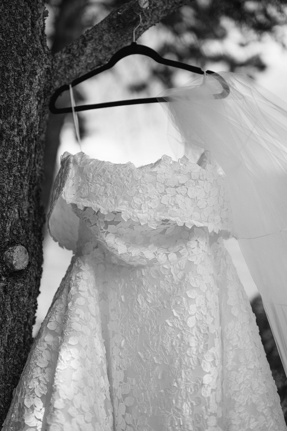 Close-up details of delicate white lace and embroidery patterns on a wedding dress bodice and skirt.