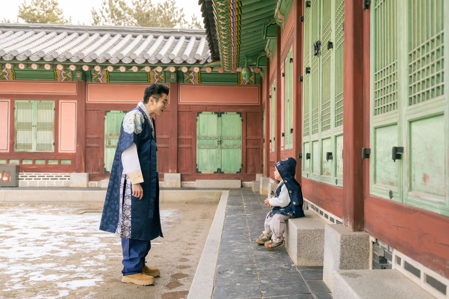 Traditional Korean palace walkway with green and red painted wooden columns and ornate roof details in Seoul.