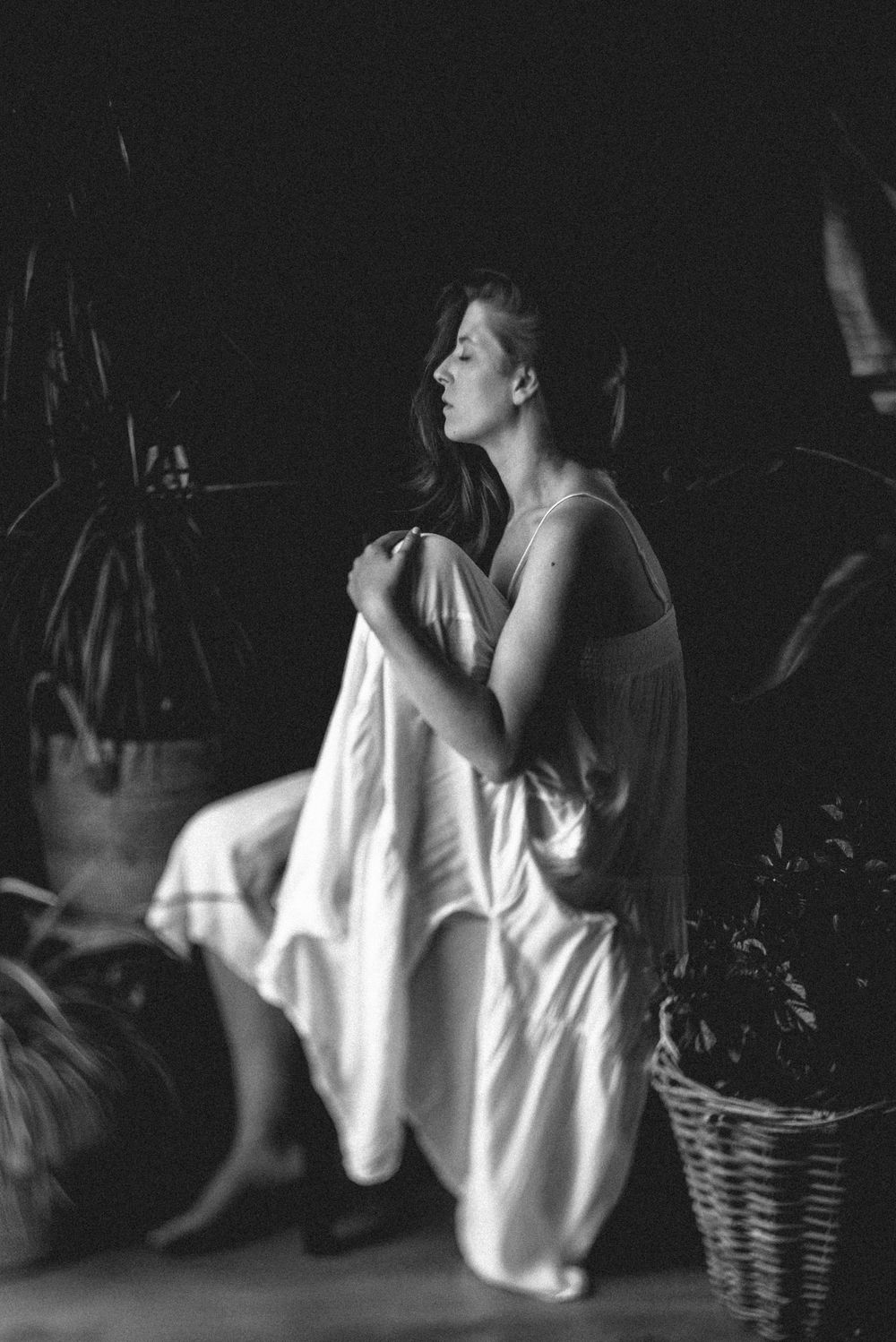 A dramatic black and white photo series showing a figure in a white shirt against a dark background in various poses.