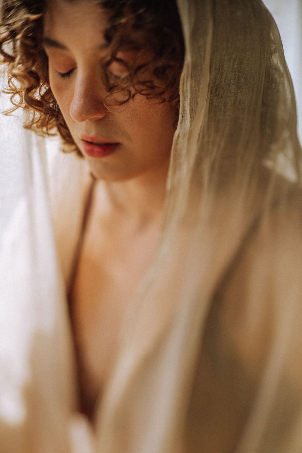 Artistic boudoir portrait series showing intimate angles of a person with curly hair in soft natural lighting.