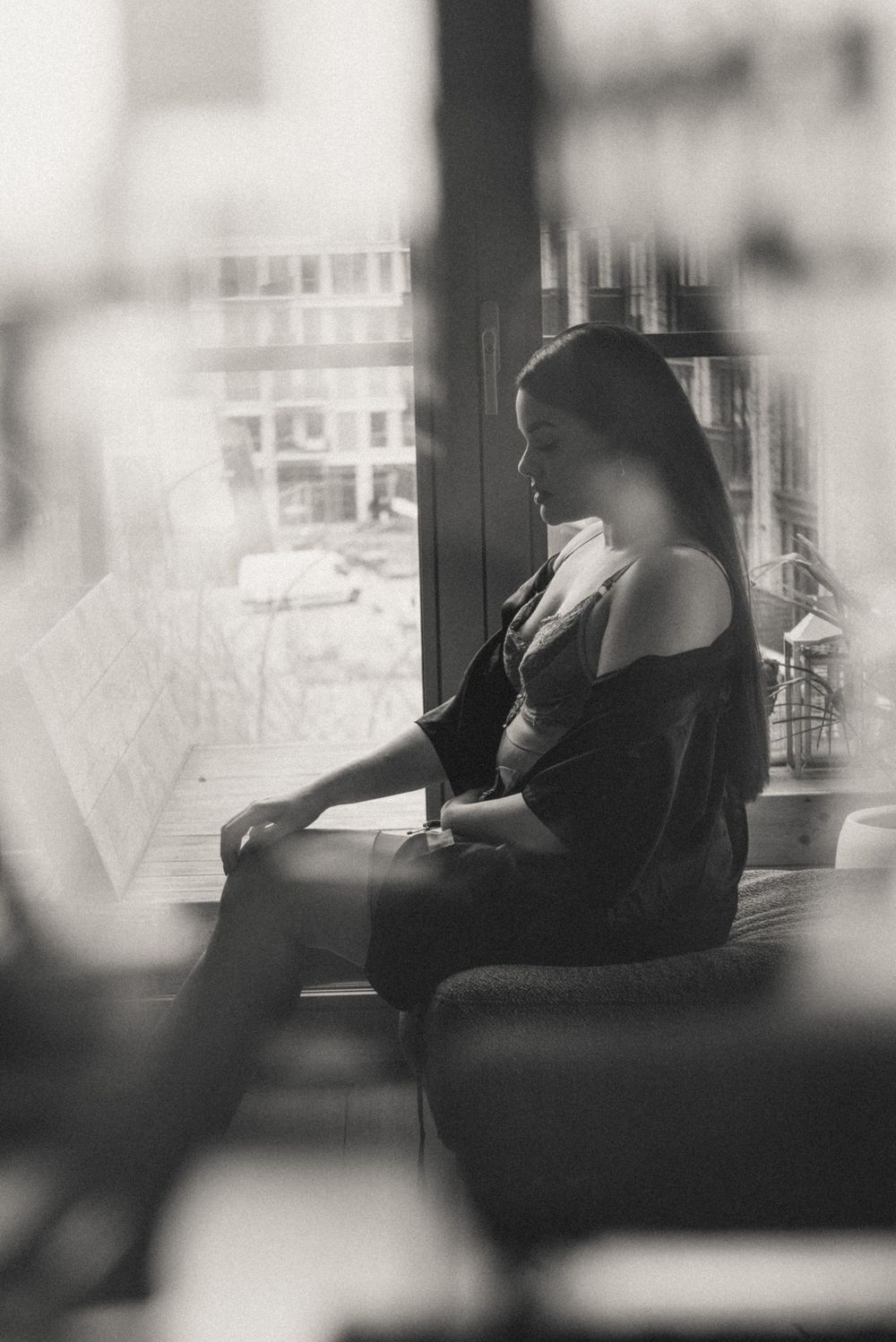 A series of black and white photographs showing a silhouette seated by a window in different poses.