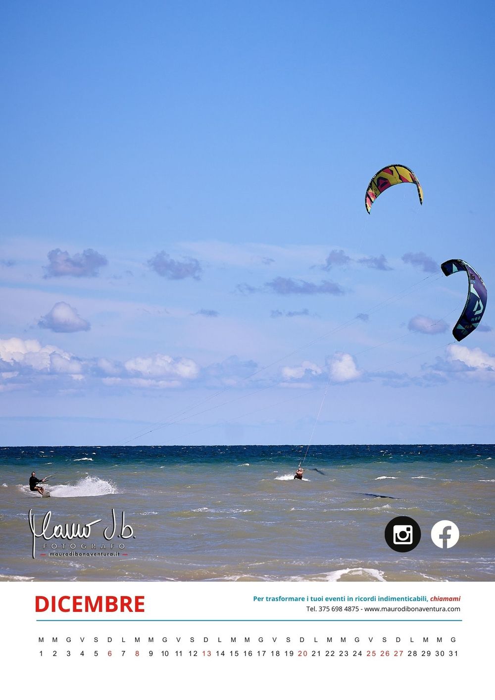 Kitesurfers riding waves on a bright blue ocean under scattered white clouds.