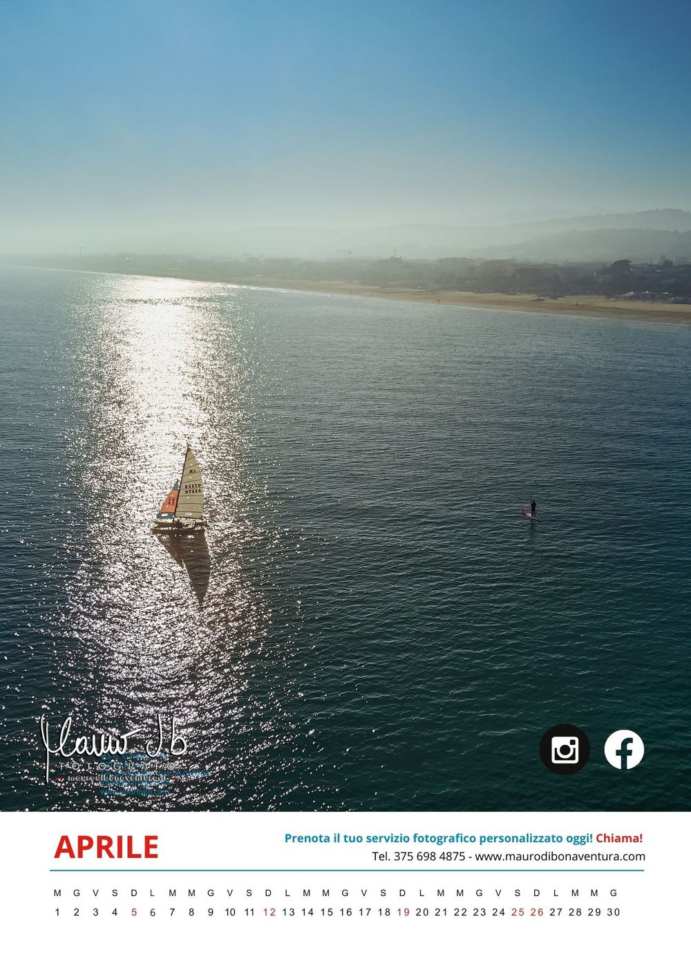 Aerial view of a sailboat gliding across sparkling blue ocean waters with distant coastline visible on a sunny day.