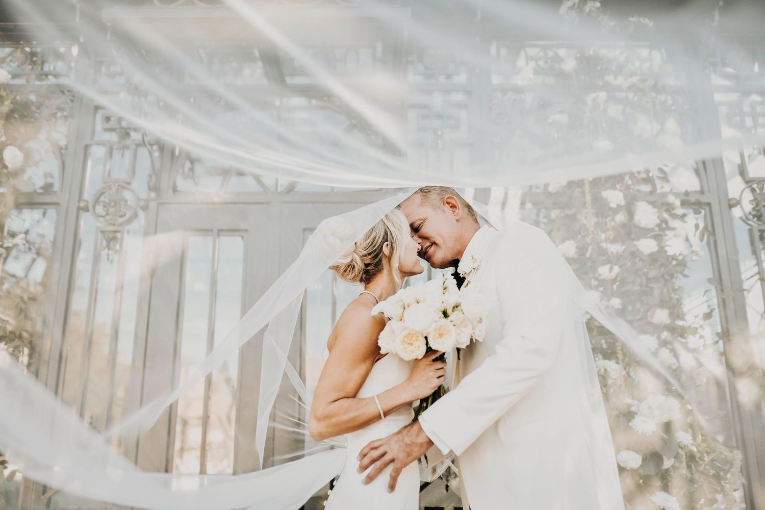 Romantic wedding photo of a couple kissing under the veil