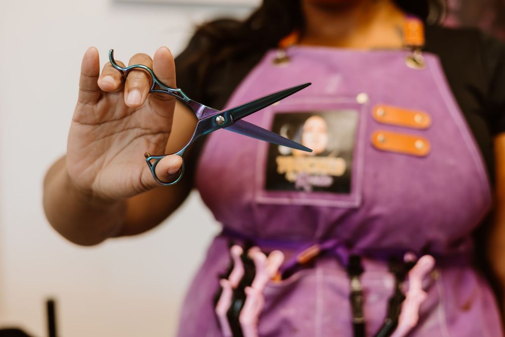 A purple chef's apron with white bones pattern is being displayed against a light background.