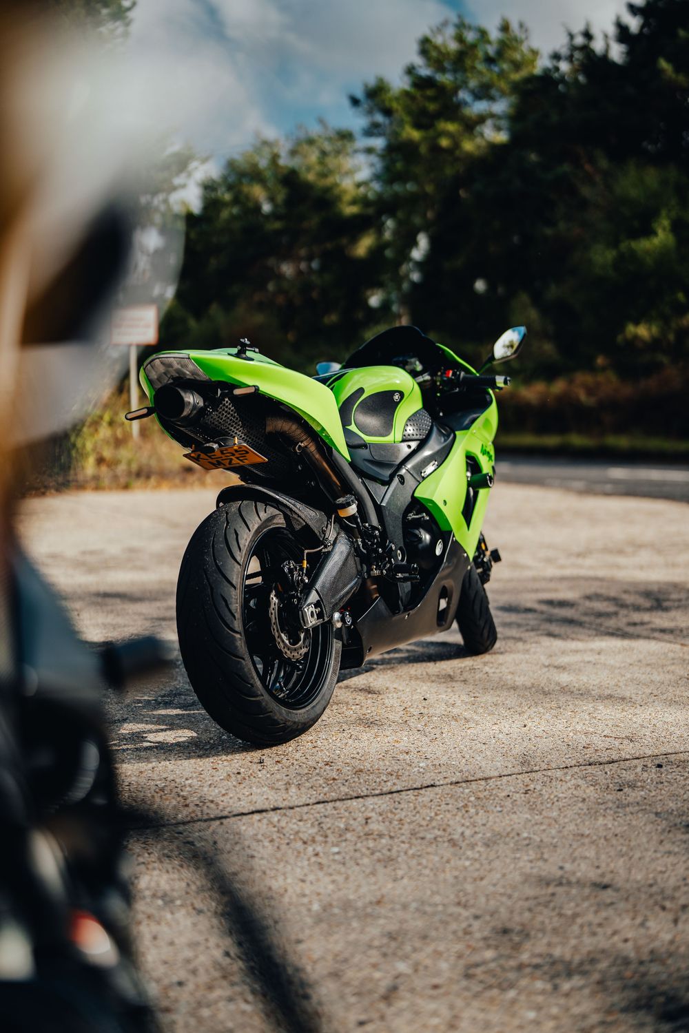 Multiple angles of a bright green sportbike parked on concrete with trees in background.