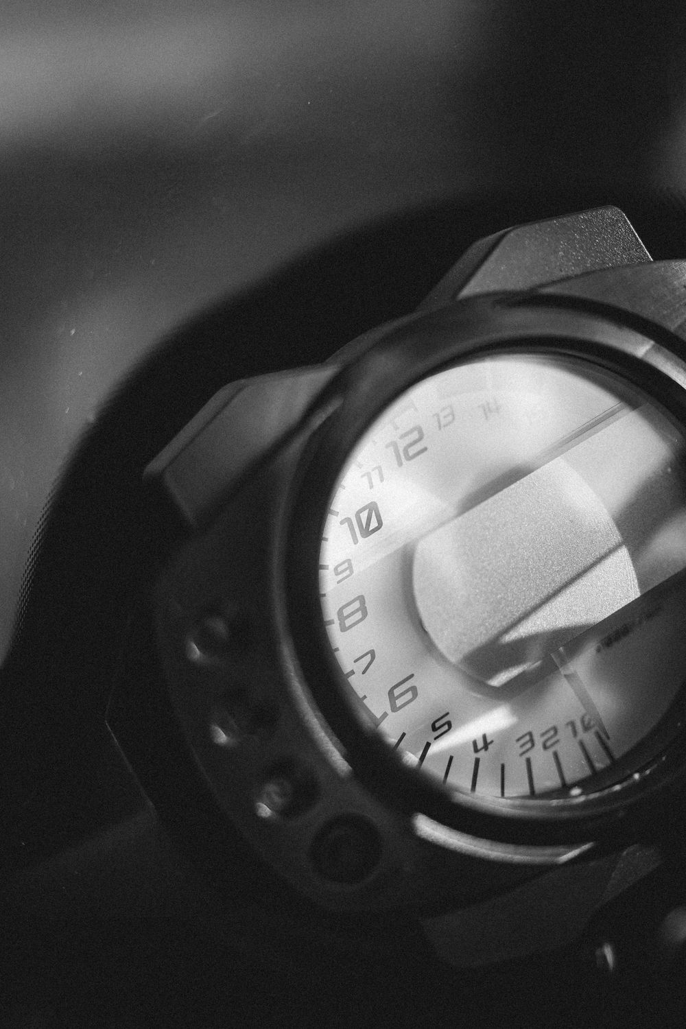 Black and white close-up sequence of a motorcycle speedometer gauge showing increasing speed.