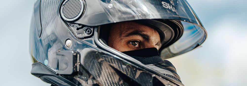 A sleek motorcycle helmet with a clear visor is shown in multiple angles against a light background.