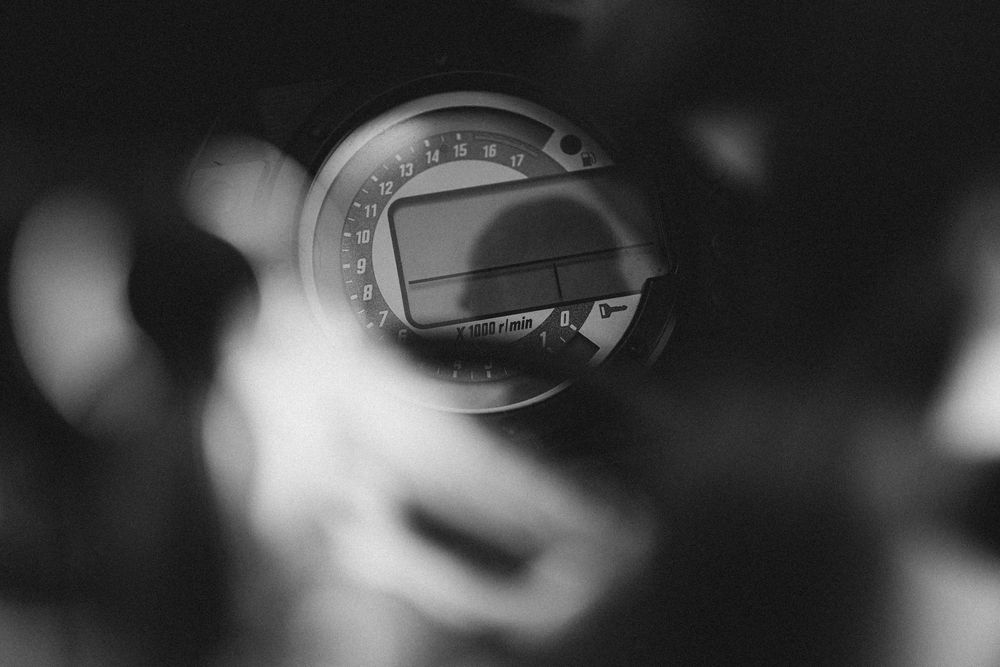 A black and white macro photograph of a bottle cap with circular details and text visible.
