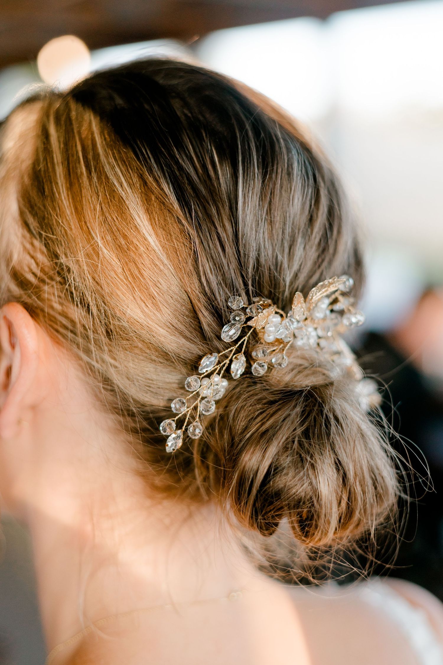Elegant bridal updo with crystal and pearl hair comb accessory, perfect for a wedding hairstyle.